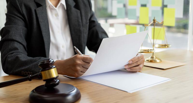 Attorneys are reviewing contract documents for the client in which the client has filed a lawsuit against an employee at a company that commits the fraud. Fraud litigation concept
