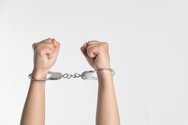 hands in handcuffs against white background