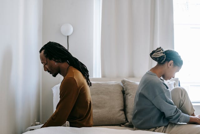 sad couple sitting on bed