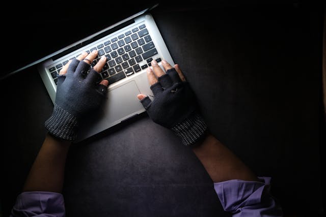 person with fingerless gloves using computer