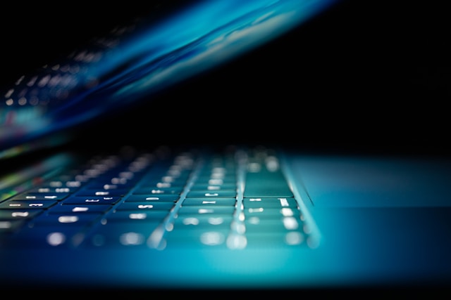 half closed computer screen and lit keyboard
