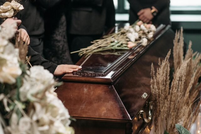 person with hand on casket